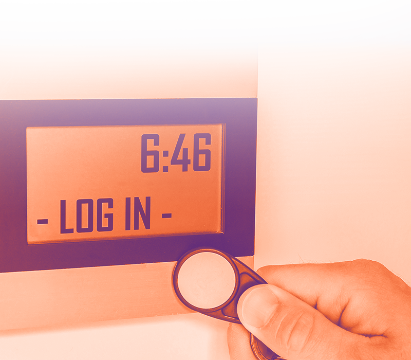 foto con gradiente arancione sfumato sul bianco dove in primo piano appare una macchinetta per timbrare e una mano con il badge