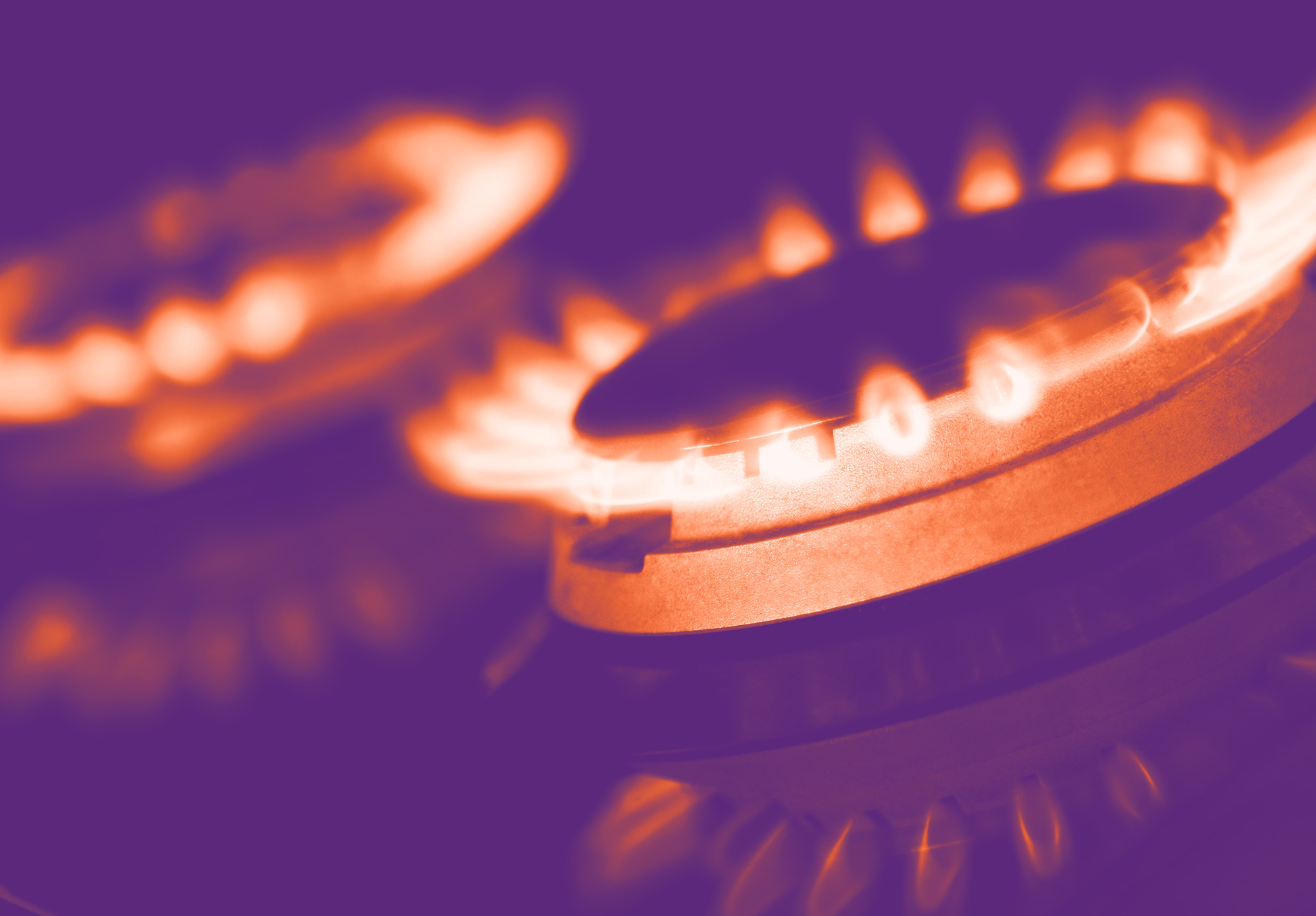 foto con gradiente viola con in primo piano un gas del fornello acceso, dove le fiamme del gas sono arancioni