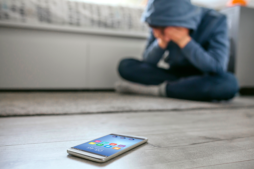 adolescete disperato con il telefono per terra