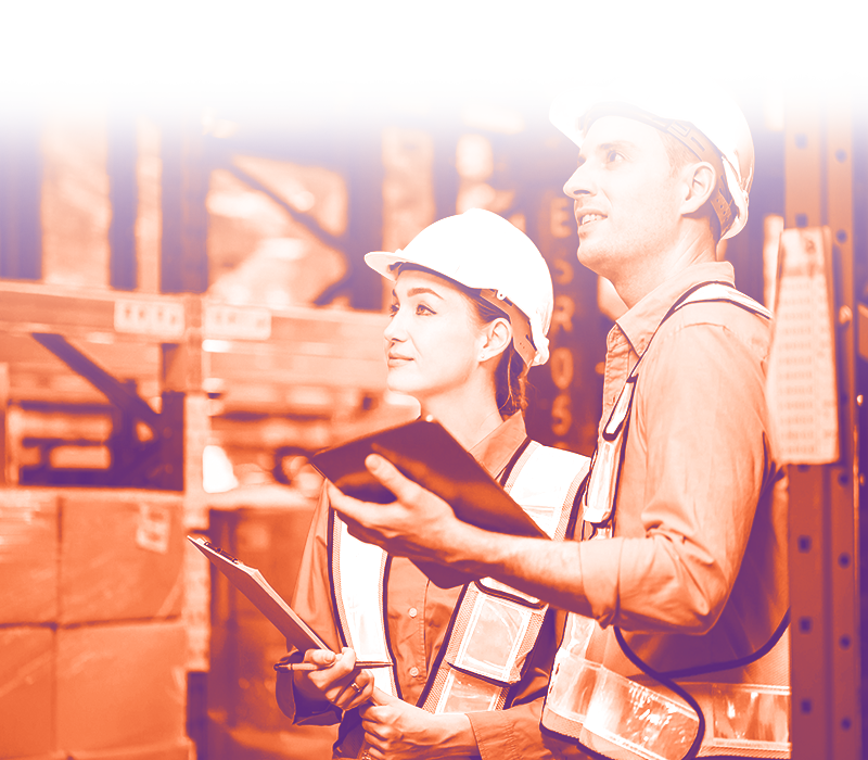 foto con gradiente arancione chiaro dove ci sono un uomo e una donna in un magazzino, con giubotto da lavoro e caschetto da lavoro che con tablet a appunti in mano guardano davanti
