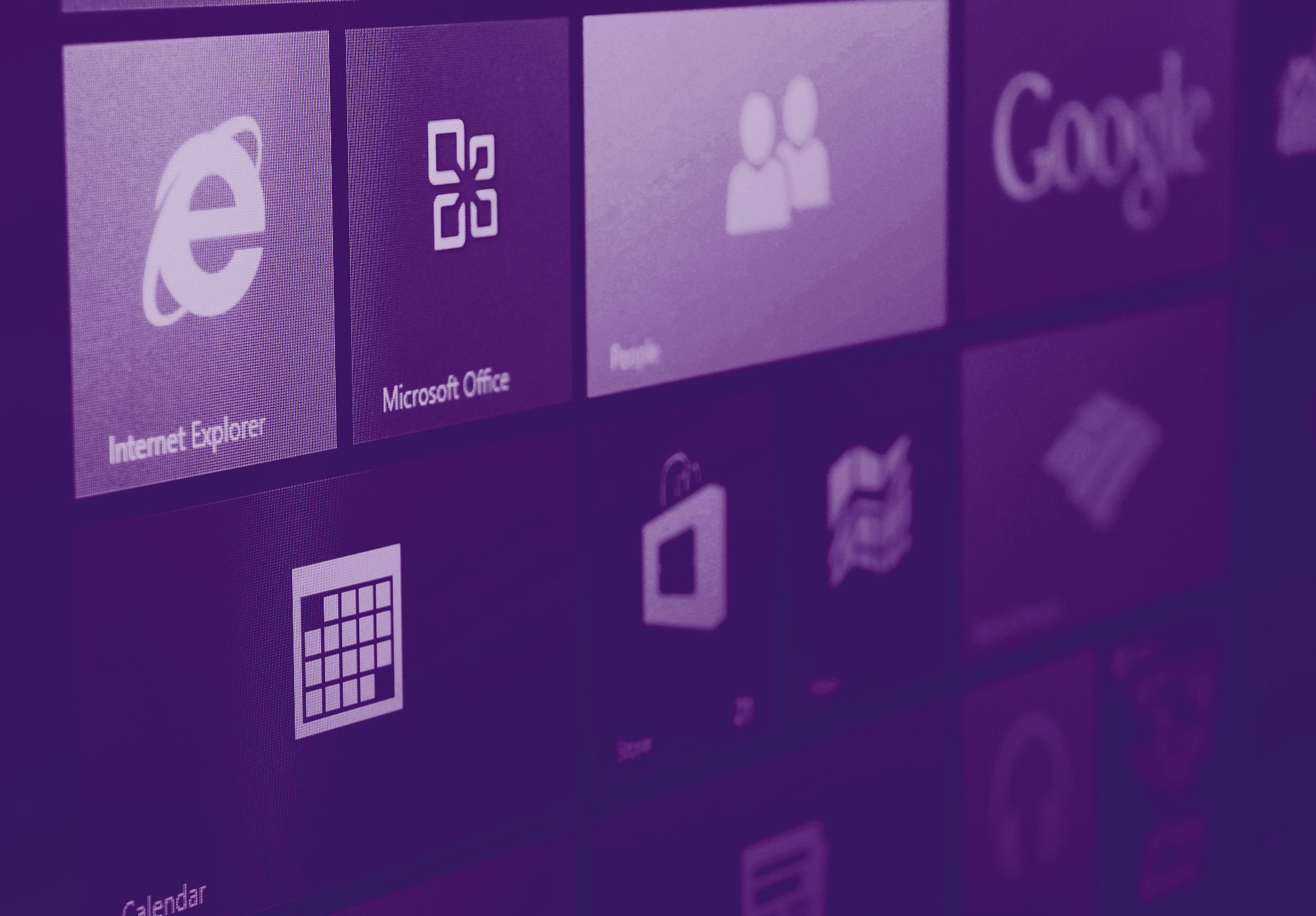 foto con gradiente viola scuro dove si vede in primo piano lo sfondo di uno schermo microsoft