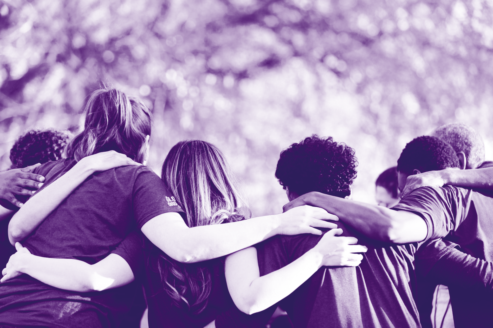 Foto con gradiente viola dove ci sono un gruppo di ragazzi di spalle che si abbracciano